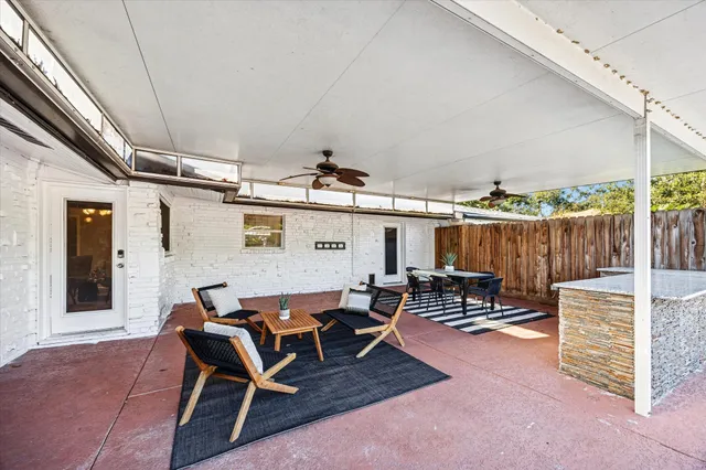 swimming pool view with a seating space and a table under an umbrella
