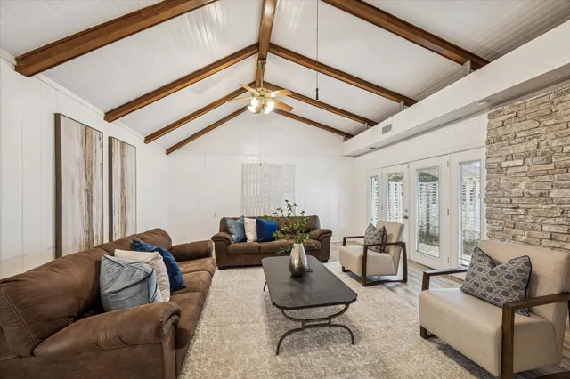 a living room with furniture and a ceiling fan