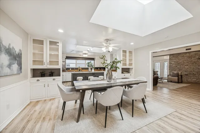 a dining hall with stainless steel appliances a dining table and chairs with wooden floor