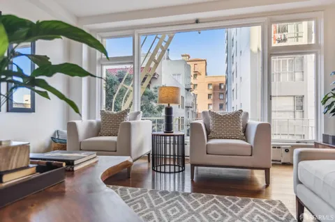 a living room with furniture fireplace and a large window
