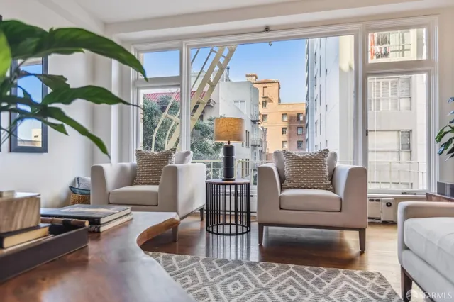 a living room with furniture fireplace and a large window