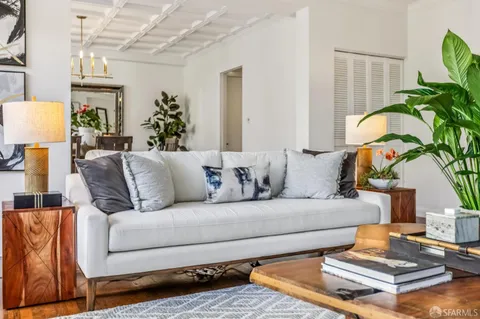 a living room with furniture flowerpot and wooden floor