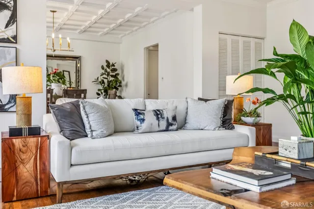 a living room with furniture flowerpot and wooden floor
