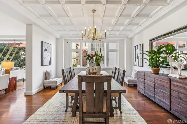 a view of a dining room with furniture a chandelier and wooden floor