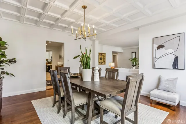 a view of a dining room with furniture a chandelier and wooden floor
