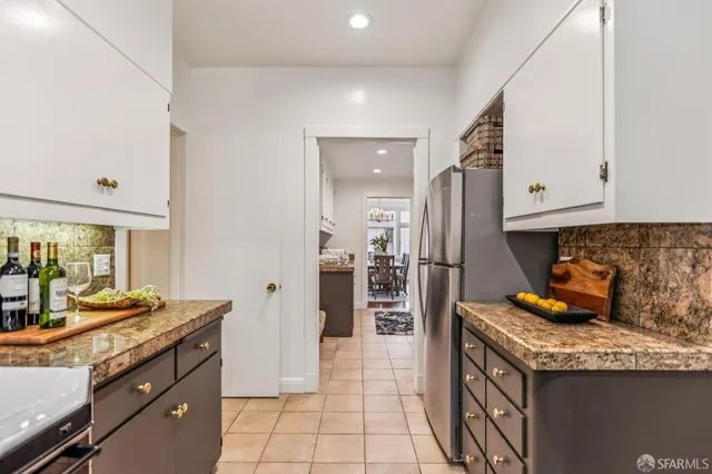 a kitchen with granite countertop a refrigerator a stove and a sink