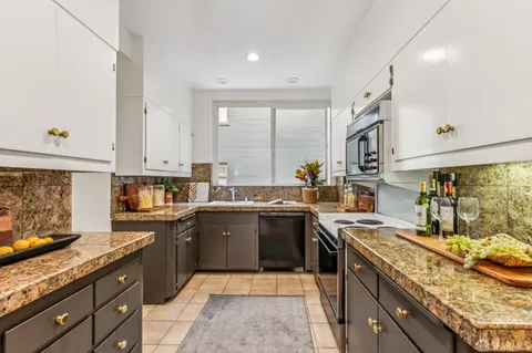 a kitchen with a sink stove top oven and cabinets