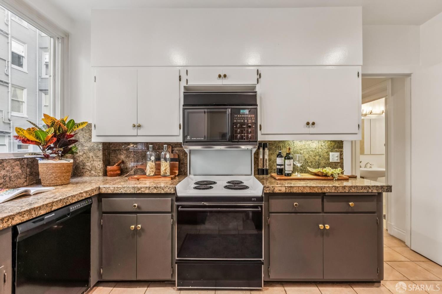 850 Powell Street, Unit 202 San Francisco, CA 94108 - Photo 30 of 51 a kitchen with stainless steel appliances granite countertop a stove a sink and a microwave