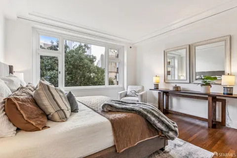 a bedroom with bed and a large window