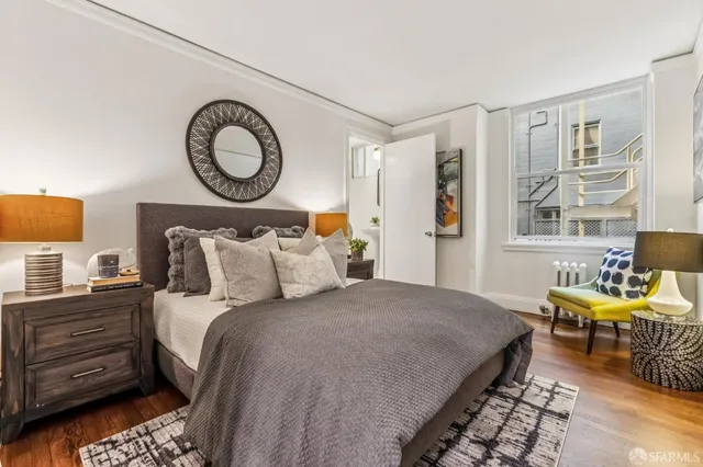 a bedroom with bed and wooden floor