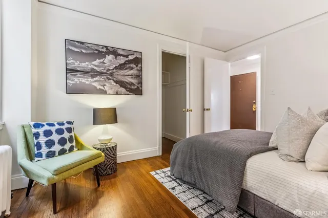 a bedroom with a bed and wooden floor