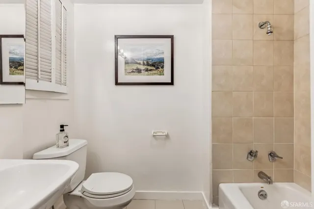 a white toilet sitting next to a bath tub