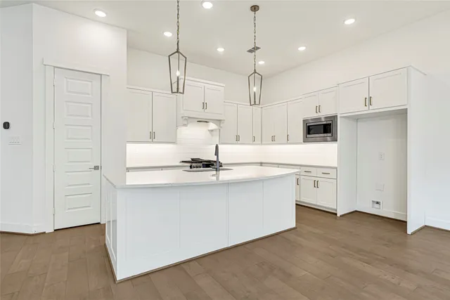 a kitchen with kitchen island a sink stainless steel appliances and cabinets