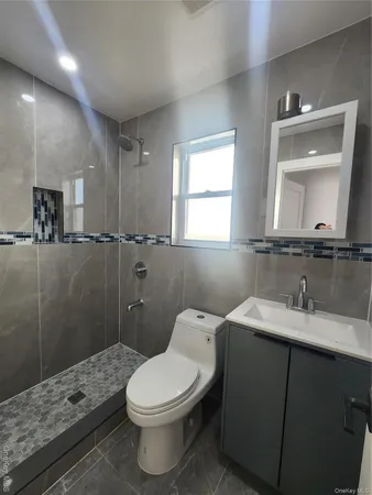 a bathroom with a sink a toilet a mirror and shower