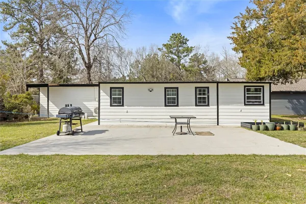 a view of a house with backyard and a tree