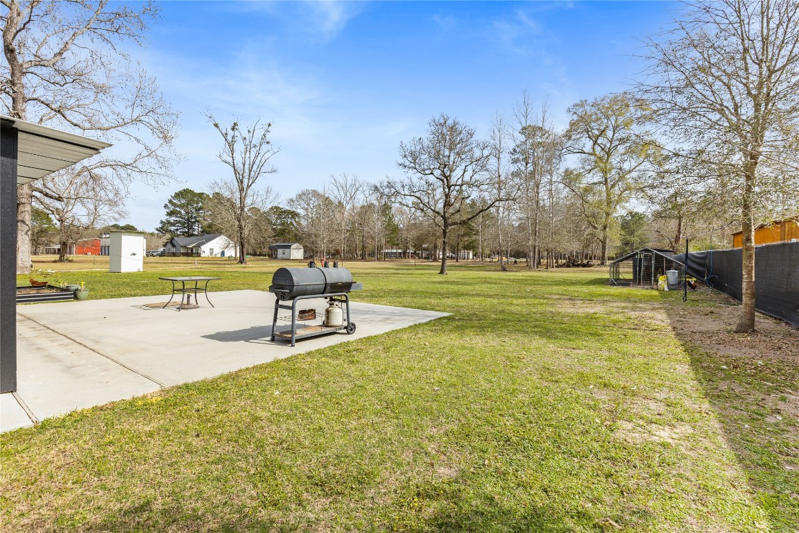 1910 Stringtown Road Shepherd, TX 77371 - Photo 24 of 24 a view of a swimming pool with a bench and trees in the background