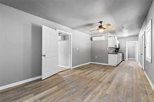 a view of a kitchen with wooden floor and a ceiling fan