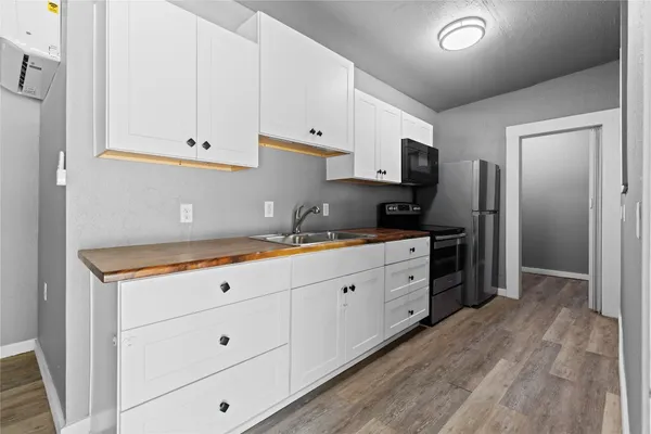 a kitchen with granite countertop white cabinets and stainless steel appliances