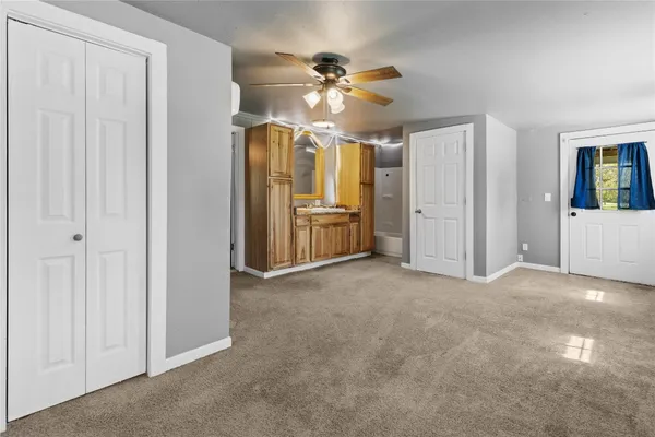 a view of a livingroom with a ceiling fan window and entryway