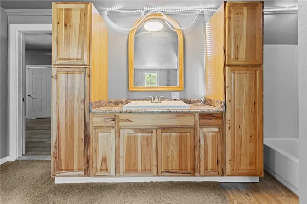 a bathroom with a granite countertop sink and a window