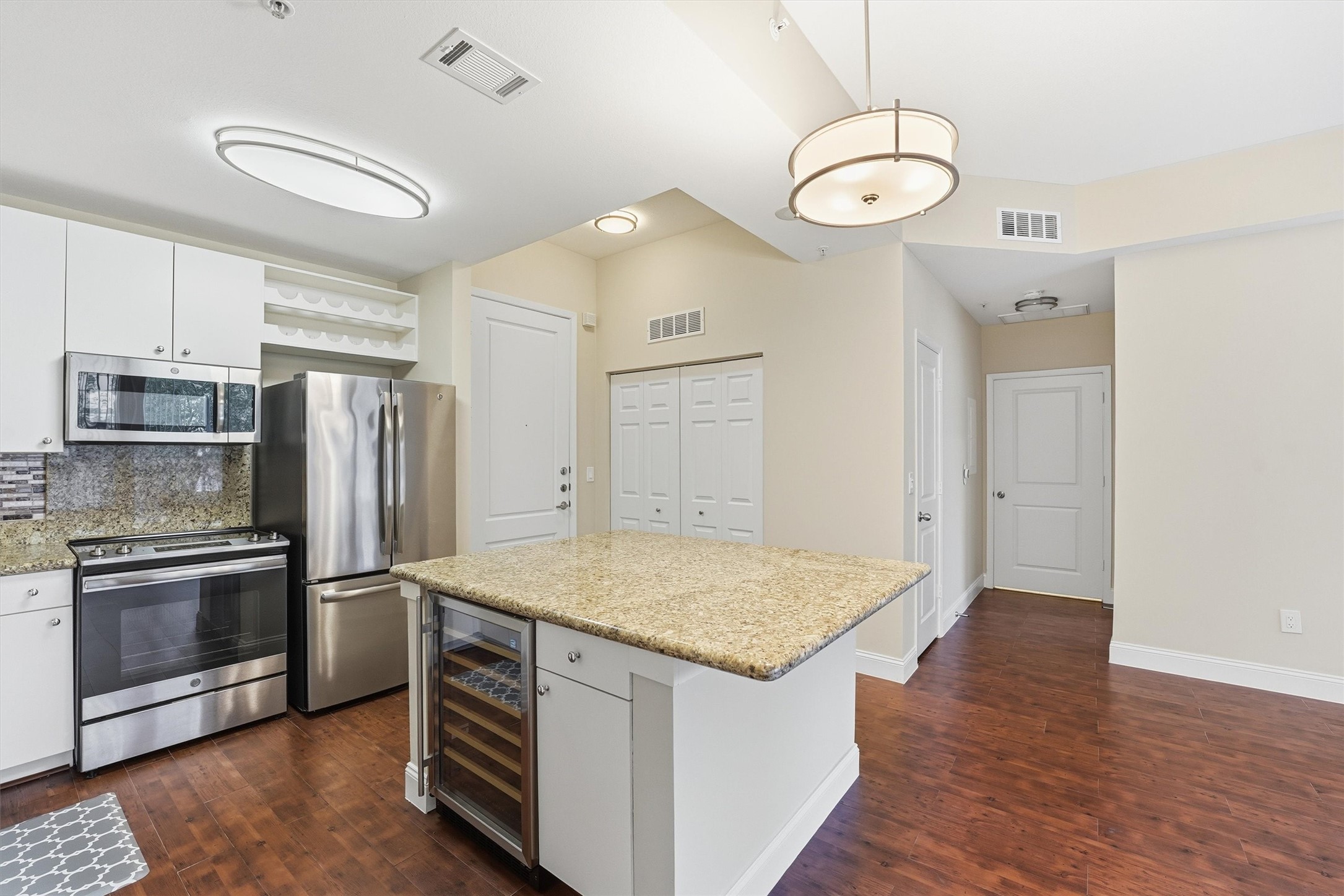 a kitchen with stainless steel appliances granite countertop a sink and a refrigerator