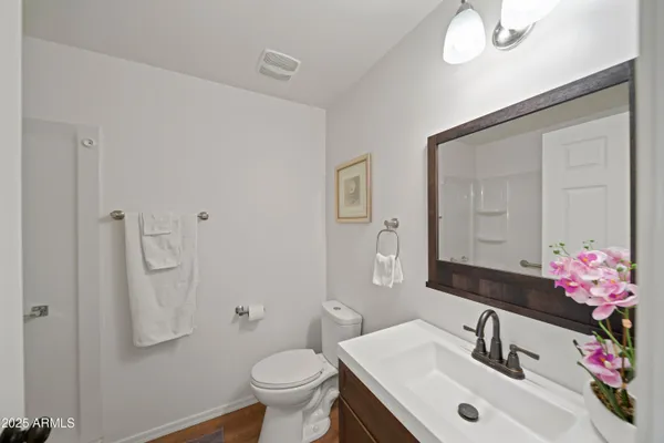 a bathroom with a sink vanity mirror and toilet