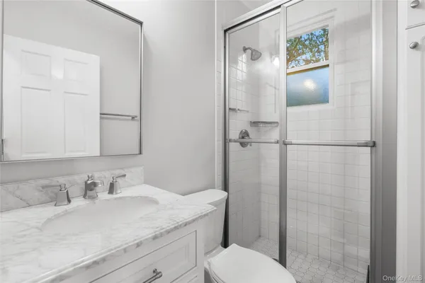a bathroom with a granite countertop sink toilet and shower