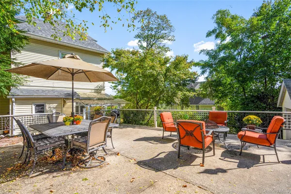 an outdoor sitting area with furniture and umbrella