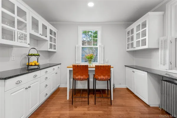 a kitchen with stainless steel appliances granite countertop a white cabinets and wooden floor