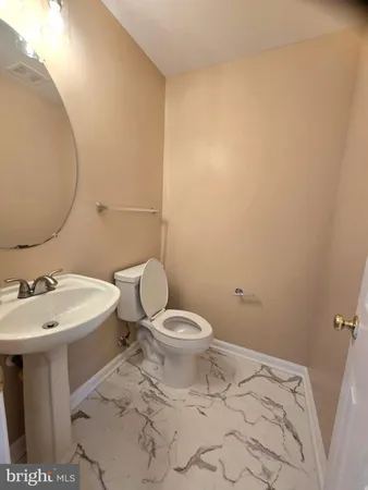 a white toilet sitting next to a bathroom sink