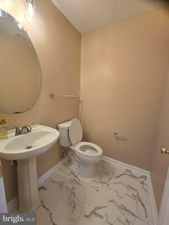 a bathroom with a sink a toilet and mirror