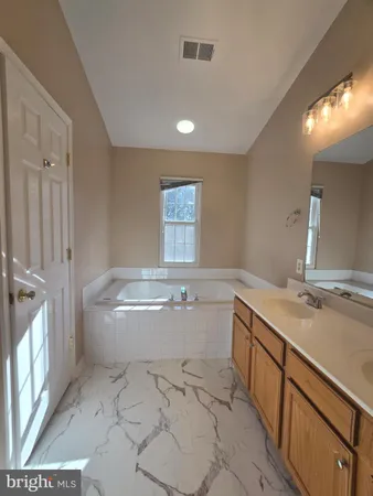 a bathroom with a granite countertop sink a toilet and bathtub