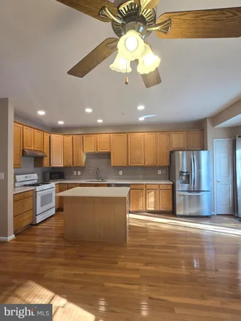 a large kitchen with stainless steel appliances kitchen island granite countertop a stove and a view of living room