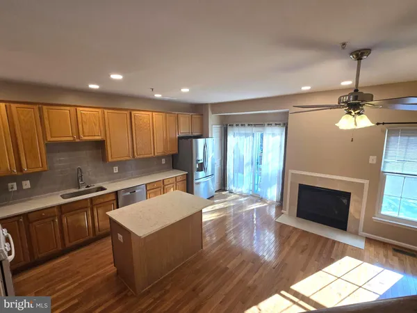 a kitchen with a stove a refrigerator sink dishwasher and cabinets with wooden floor