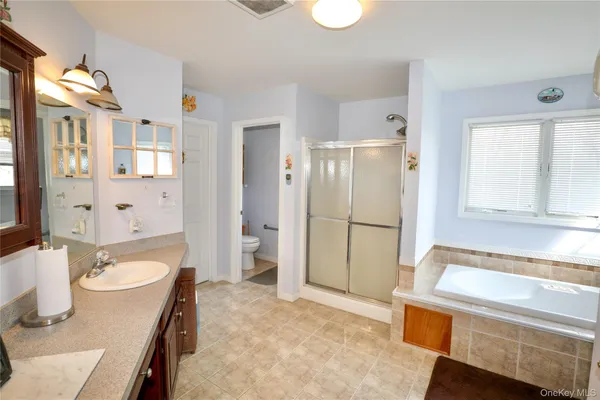a bathroom with a granite countertop sink a mirror and a bathtub