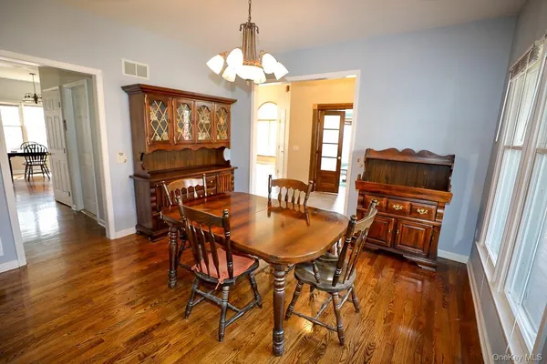 a dining room with furniture a chandelier and wooden floor