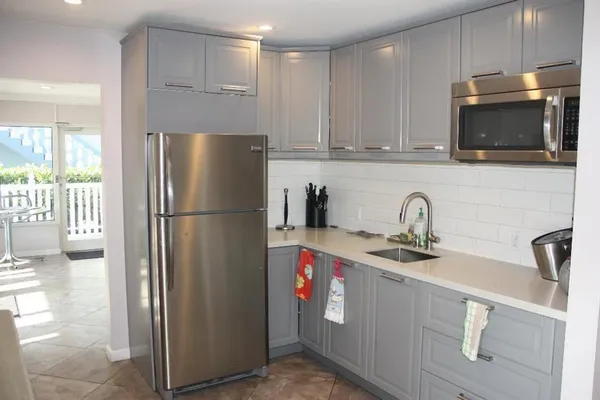 a kitchen with stainless steel appliances granite countertop a refrigerator a stove a sink and a microwave