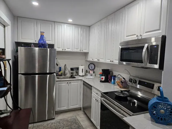 a kitchen with stainless steel appliances granite countertop a refrigerator stove and sink