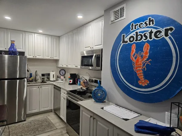 a kitchen with stainless steel appliances granite countertop a sink a stove a refrigerator and cabinets
