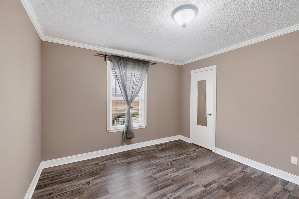 2200 East Trinity Mills Road, Unit 616 Carrollton, TX 75006 - Photo 11 of 25 an empty room with wooden floor and windows