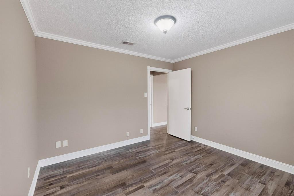 2200 East Trinity Mills Road, Unit 616 Carrollton, TX 75006 - Photo 13 of 25 an empty room with wooden floor and windows