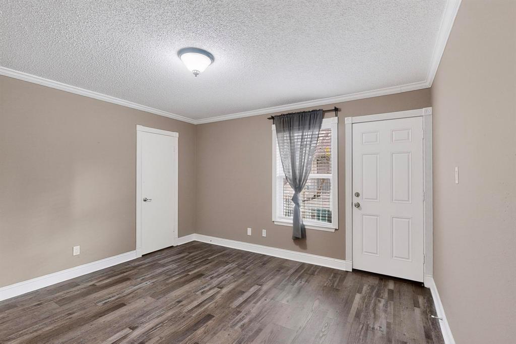 2200 East Trinity Mills Road, Unit 616 Carrollton, TX 75006 - Photo 23 of 25 a view of an empty room with wooden floor and a window