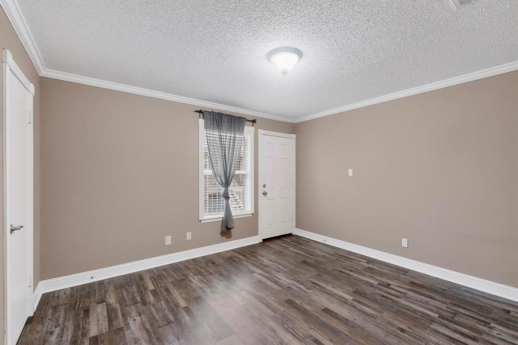 2200 East Trinity Mills Road, Unit 616 Carrollton, TX 75006 - Photo 8 of 25 a view of an empty room with wooden floor and a window