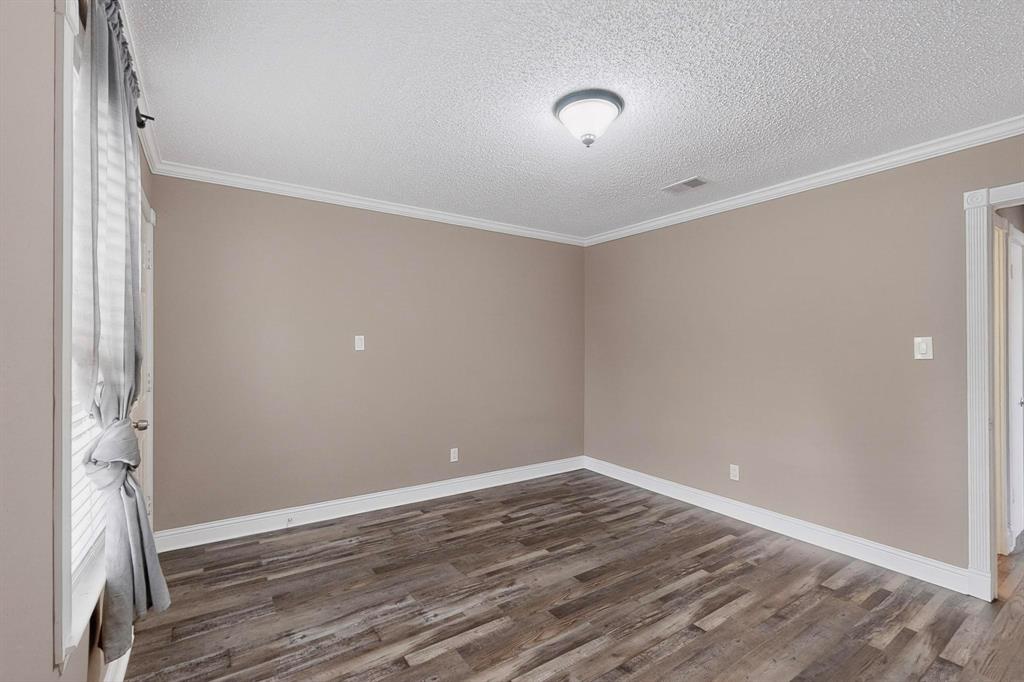2200 East Trinity Mills Road, Unit 616 Carrollton, TX 75006 - Photo 10 of 25 a view of an empty room with wooden floor and a window