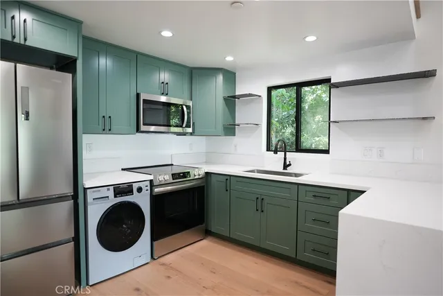 a kitchen with a sink cabinets and stainless steel appliances