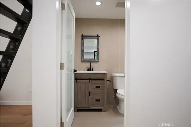 a bathroom with a toilet a sink and mirror