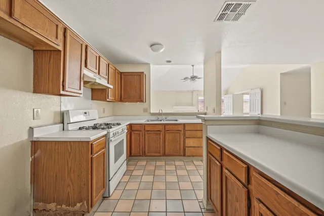 a kitchen with a sink stove top oven and cabinets