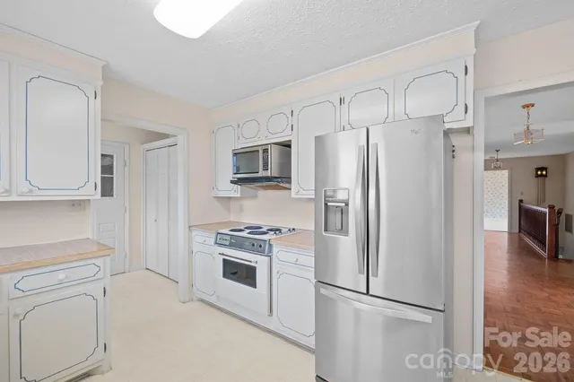 a kitchen with cabinets stainless steel appliances and wooden floor