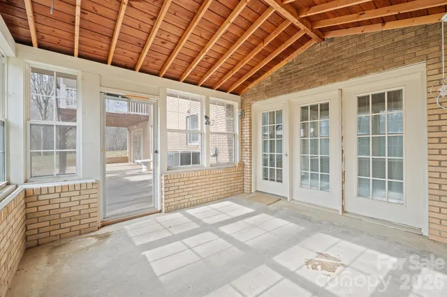 a view of front door with wooden floor and windows