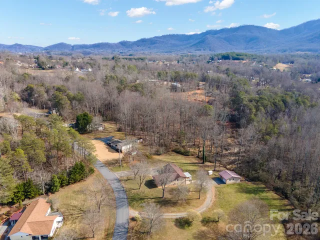 an aerial view of a house with a mountain